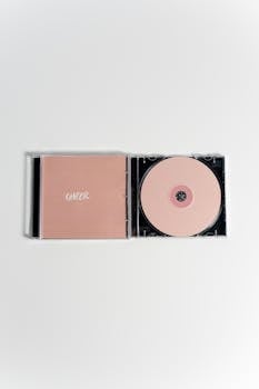 Minimalist pink CD and case representing breast cancer awareness.